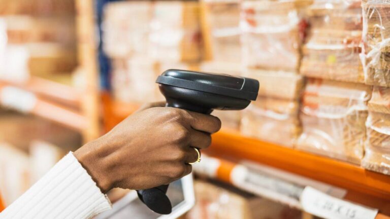 a person using barcode reader to scan the inventory in his warehouse