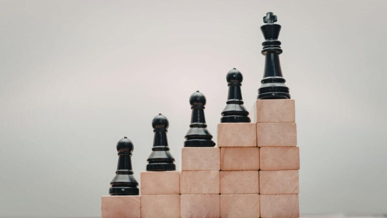 growth represented by chess pieces on wooded blocks